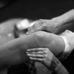 Ballerina sticks kinesio tape on the knee and lower leg
