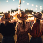 Women in country clothes on music festival. Blurred background with bulb lights.