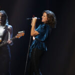 Sarah McLachlan performs on stage in a blue dress with a background singer behind her